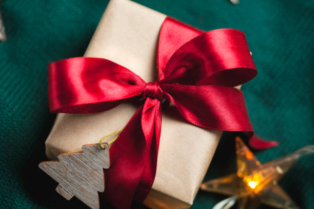 istock Christmas gift boxe wrapped in craft paper with red ribbon 1355987445