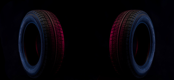 winter wheel for a car on a stylish black and blue red background.