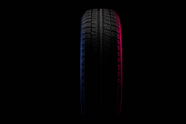 istock tire with winter tread in profile on black background with blue red light 1355988556