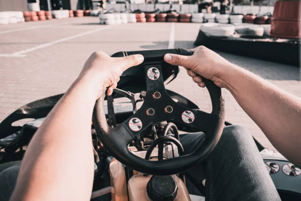 A young man drives a go kart at circuit.