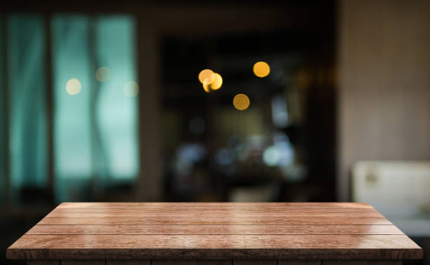 istock Empty wooden table top with lights bokeh on blur restaurant background 1355993145