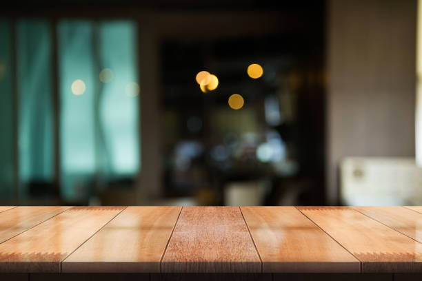 istock Empty wooden table top with lights bokeh on blur restaurant background 1355993158
