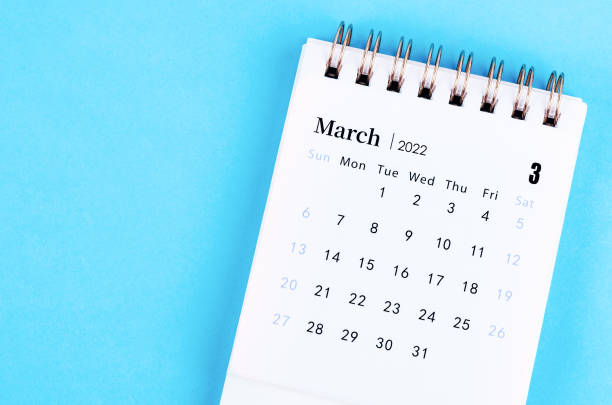 istock March 2022 desk calendar on blue background. 1355995393