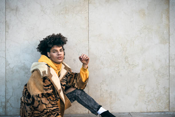 Young Afro gay man posing while looking into the camera Young Afro gay man posing while looking into the camera gay person photos stock pictures, royalty-free photos & images