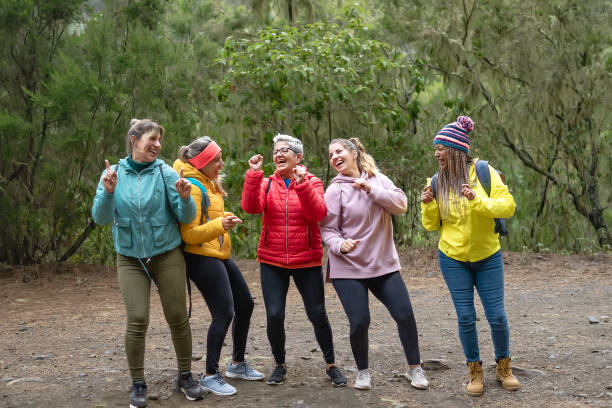 group of women with different ages and ethnicities having a funny moment dancing during a walk foggy forest - adventure and travel people concept - life events laughing women latin american and hispanic ethnicity imagens e fotografias de stock
