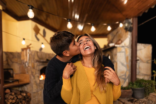 une mère hispanique souriante et heureuse passe un moment tendre avec son fils - concept d’amour familial et d’unité - mothers day mother kissing child photos et images de collection
