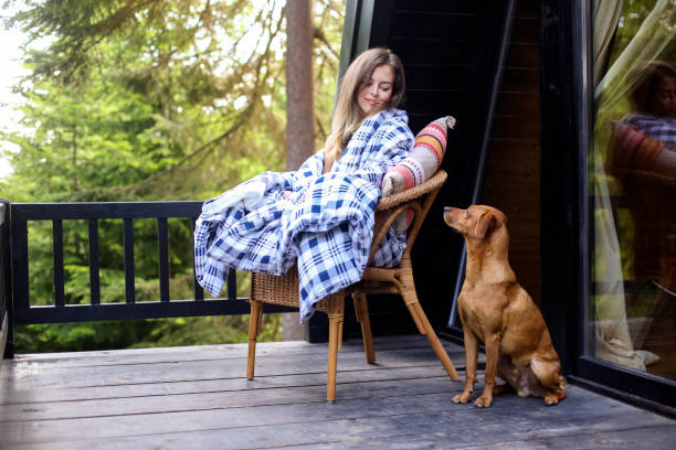 Vacation with a pet Young woman with her pet dog in a mountain cottage. About 25 years old, Caucasian female. pine woodland stock pictures, royalty-free photos & images