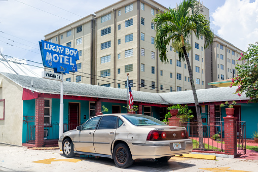 Miami, USA - July 23, 2021: Road street in Hollywood, Florida with vintage retro cheap motel hotel called Lucky Boy with tv and vacancy sign