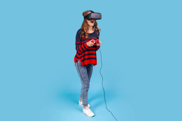 vrメガネヘッドセットの女性は、手にジョイスティックを保持し、ゲームを経験し、興奮した表情をします。 - gamer video game video computer ストックフォトと画像