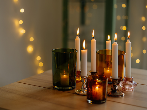 Table christmas decoration with many candle light holders burning modern home decor
Photo taken indoors in natural light