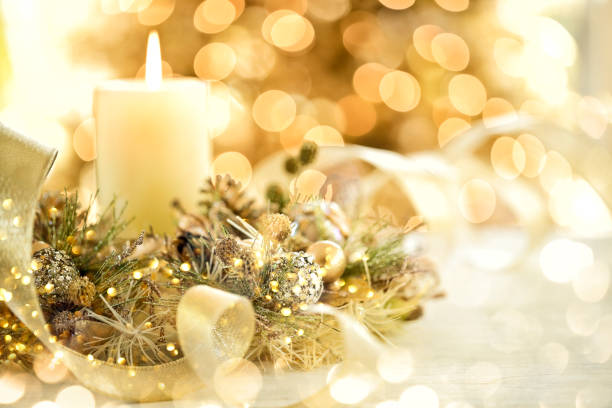 istock Christmas Candle against a Gold Christmas Tree 1356004128