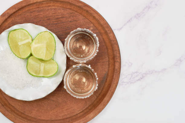 istock Shot of tequila with lime and salt on white background 1356004971