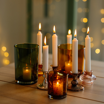 Table christmas decoration with many candle light holders burning modern home decor
Photo taken indoors in natural light