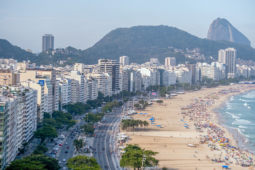 Rio de Janeiro city, Rio de Janeiro state, Brazil - October 03, 2021:People enjoying a hot summer day on the most famous beach and avenue in  Rio.
