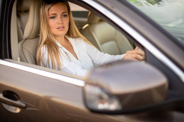 istock Pretty, young woman  driving a car 1356007556