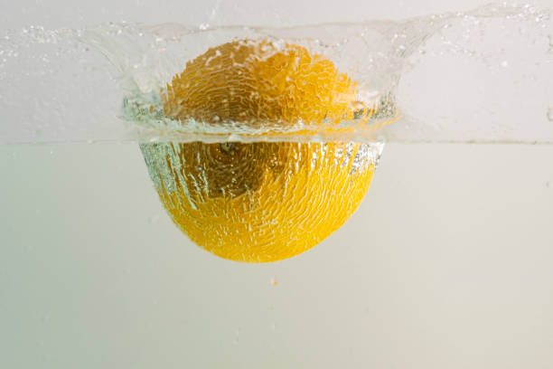 Beautiful view of melon falling into water on turquoise background. Gorgeous backgrounds.