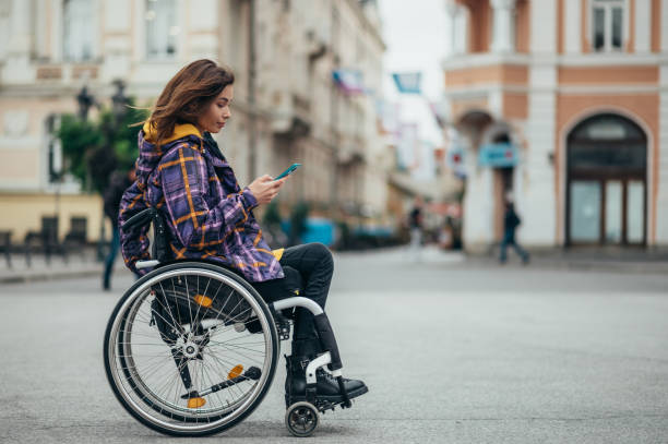 istock Woman with disability using a smartphone while out in the city 1356010133