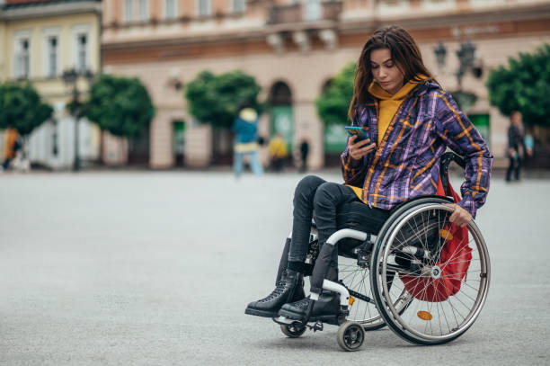 istock Woman with disability using a smartphone while out in the city 1356010140