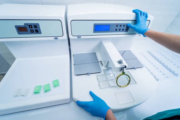 Laboratory assistant works at paraffin wax dispenser tissue embedding machine.
