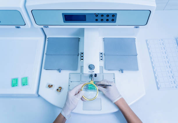 istock Laboratory assistant works at paraffin wax dispenser tissue embedding machine. 1356012779