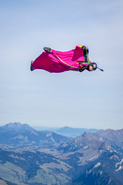 istock Man in wingsuit glides through clear skies 1356014176