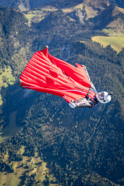 istock Man in wingsuit glides through clear skies 1356014203