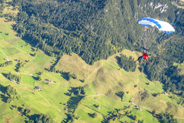 il parapendio vola attraverso cieli limpidi e soleggiati - outdoors nature paragliding autumn foto e immagini stock