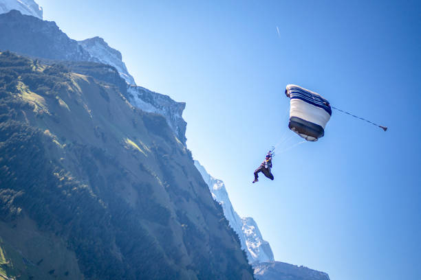 istock Paraglider flies through clear, sunny skies 1356014344