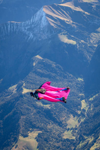istock Man in wingsuit glides through clear skies 1356014346