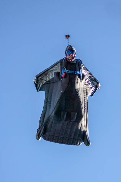 istock Man in wingsuit glides through clear skies 1356014349
