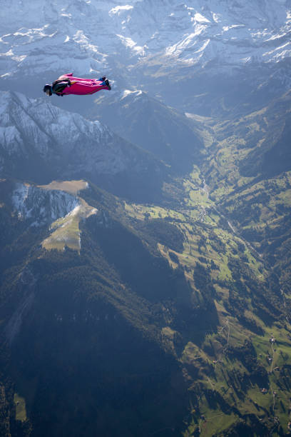 istock Man in wingsuit glides through clear skies 1356014364