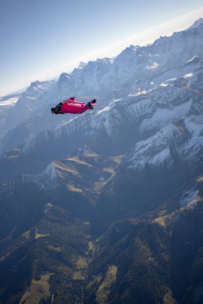istock Man in wingsuit glides through clear skies 1356014369