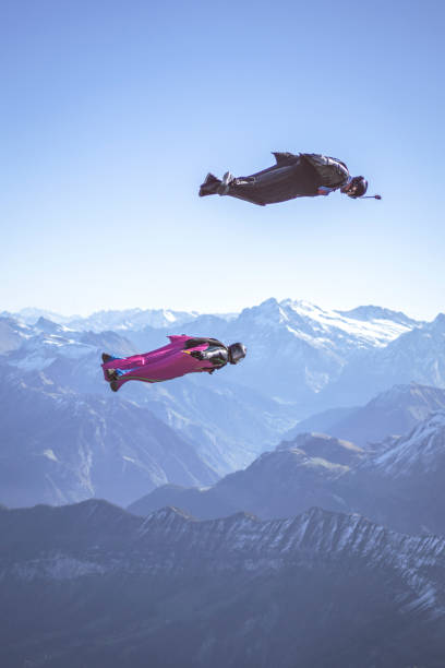 istock Friends in wingsuits glide through clear skies 1356014377