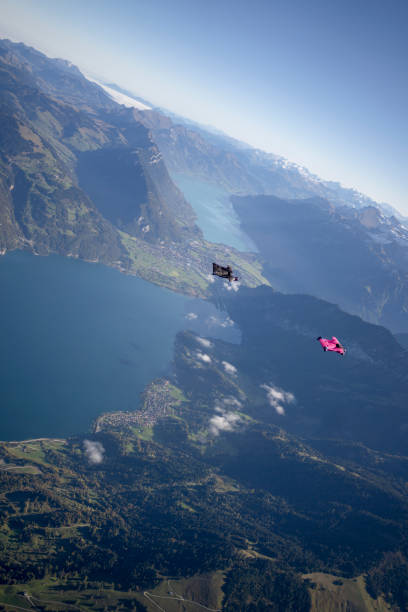 istock Man in wingsuit glides through clear skies 1356014383