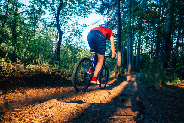 istock Extreme biker riding his bicycle downhill while wearing no safety equipment while hitting the brakes hard on a dirt trail. 1356016877