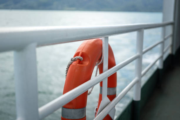 A rescue lifebuoy which is installed on ship corridor rail, stand by for people overboard into the sea. Emergency equipment for transportation object photo. Selective focus.