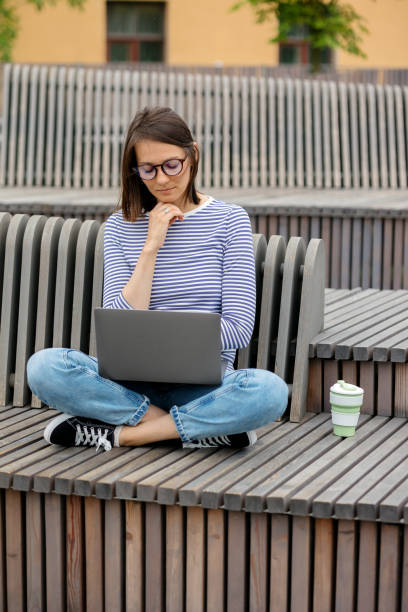 istock young and confident woman blogger or marketer drinking coffee and working on her laptop. work in a park or public place. social media or work as a top manager 1356016997