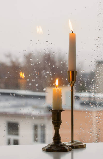 istock burning candles on background rainy window pane 1356018419
