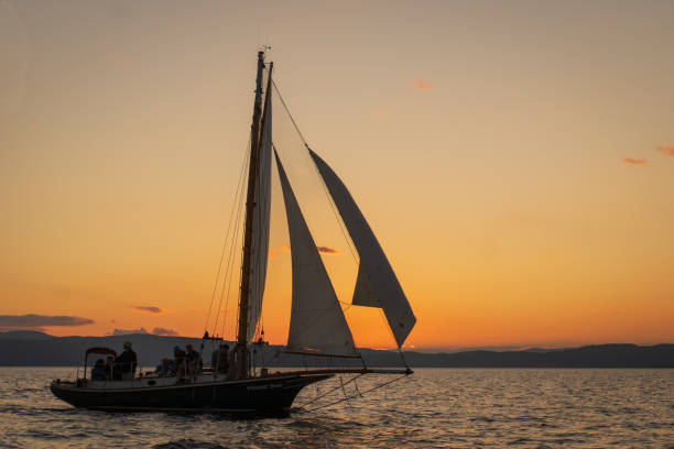 gaff-rigged sloop at sunset historic  gaff-rigged "Friendship" sloop at sunset on Lake Champlain, Burlington, Vermont gaff sails stock pictures, royalty-free photos & images
