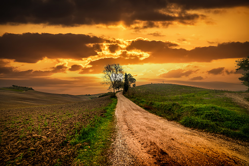 Colorful sky over a dirt road in Tuscany countryside, Italy