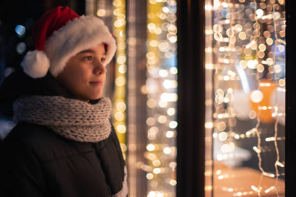 istock Boy in Santas hat looking in shop window 1356021805