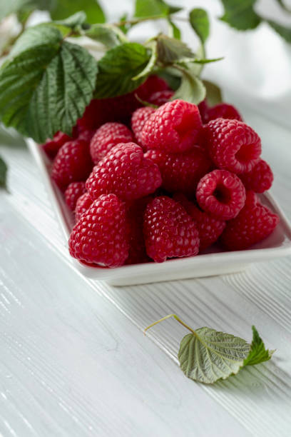 istock Fresh juicy raspberries with leaves. 1356021844