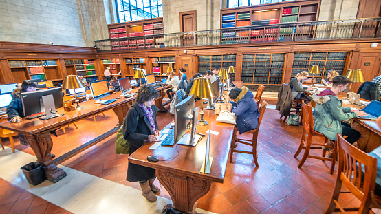 New York Public Library, New York, USA - September 18, 2023.  A panoramic interior of students reading and researching subjects in the historic Rose Main Reading Room at The New York Public Library in Midtown Manhattan