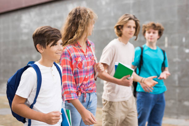 istock Group of four teens going home from school 1356023388