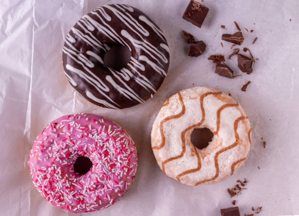 istock donuts drizzled with sugar glaze lie on white culinary paper 1356026071