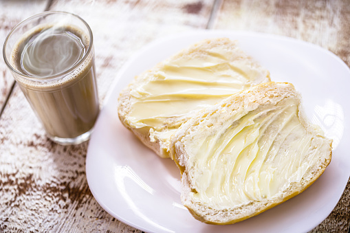 Brazilian snack, bread and butter called cacetinho or French bread, served with coffee with milk called pingado