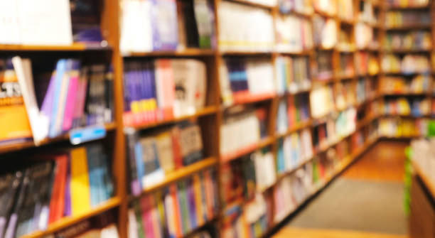 fondo borroso de la estantería de libros decorada con madera y luz cálida - bookstore fotografías e imágenes de stock