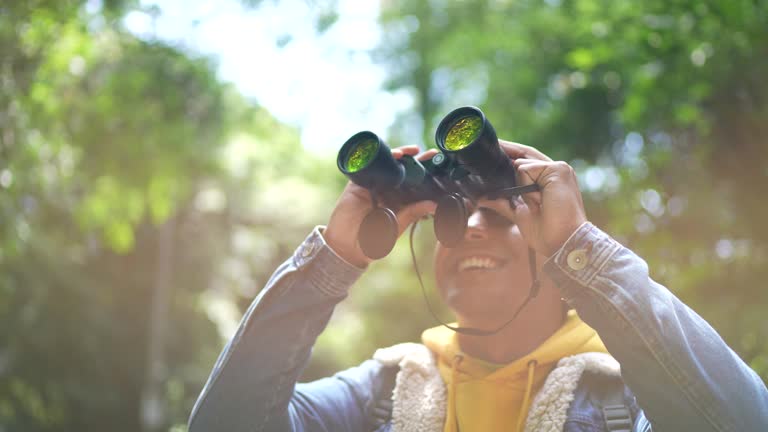 Young man using binoculars during hiking