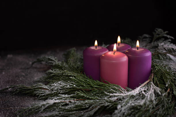 istock Christmas wreath with four burning purple advent candles. 1356031402
