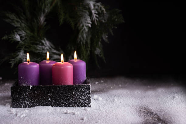istock Christmas eve, one pink and three purple advent candles. 1356031425